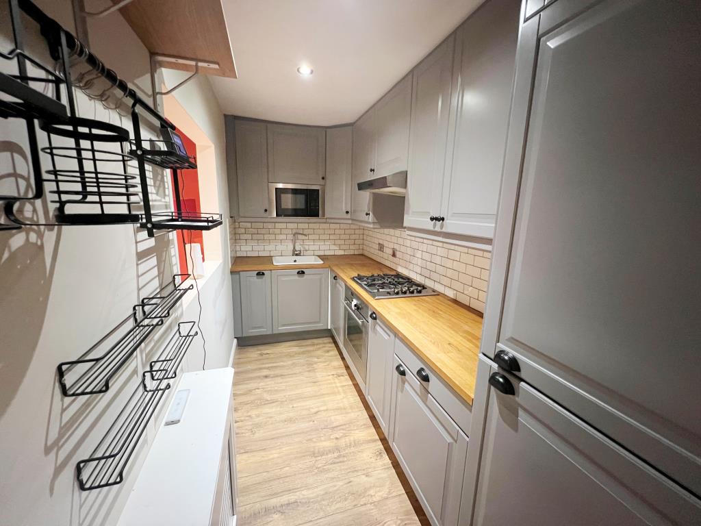 Lot: 79 - GARDEN FLAT IN POPULAR VILLAGE - Modern fitted kitchen with serving hatch to living room